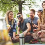 Gruppo di amici sorridenti che fa un picnic nella natura