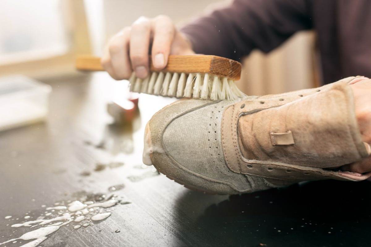 persona che pulisce scarpe con una spazzola