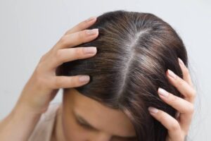 donna con le mani in testa su capelli grigi