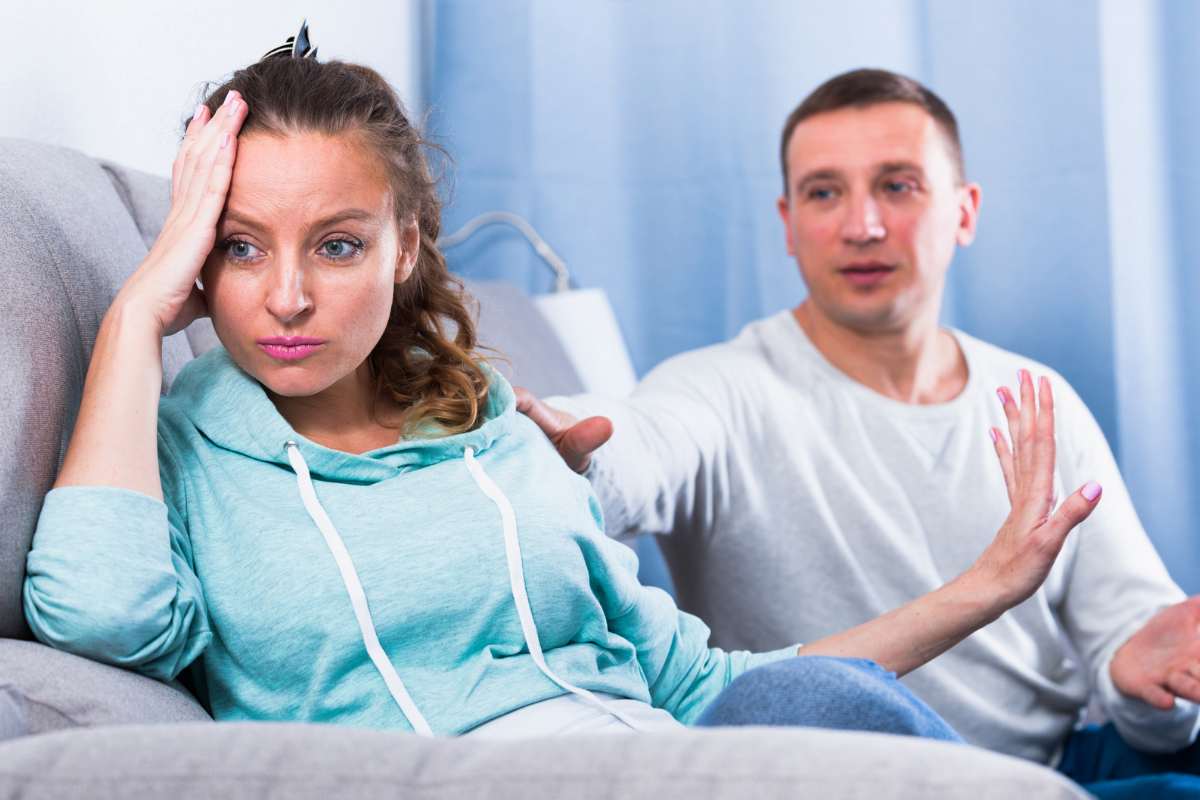 Uomo e donna che discutono sul divano