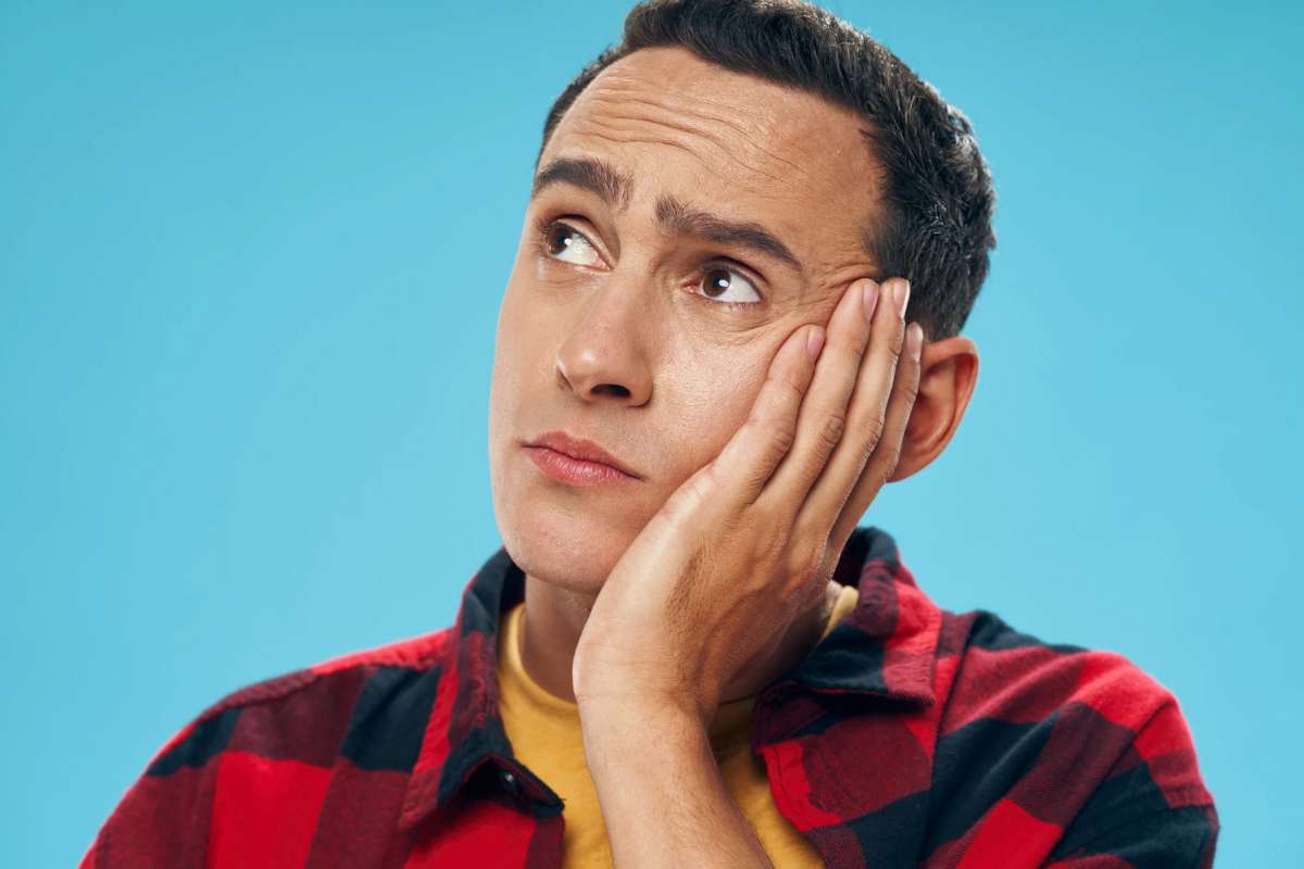 Uomo che pensa con mano sulla guancia