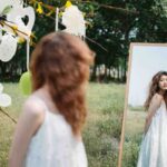 Donna che si guarda allo specchio immersa nella natura