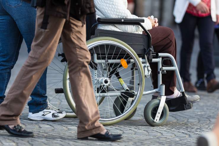 Sedia a rotelle in mezzo alla gente