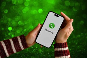 Telefono in mano con logo WhatsApp