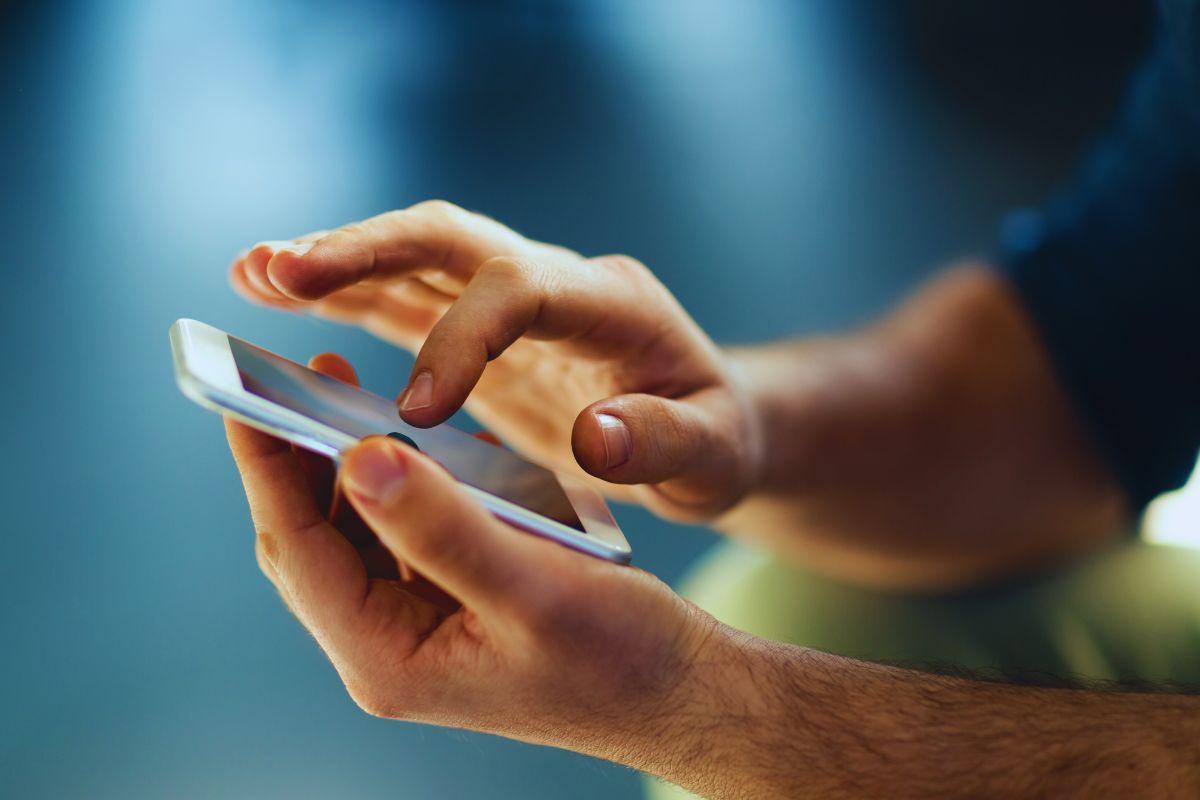Uomo che tocca lo schermo dello smartphone