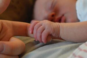 Neonato stringe il dito alla mamma