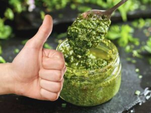sfondo pesto e pollice in su di mano