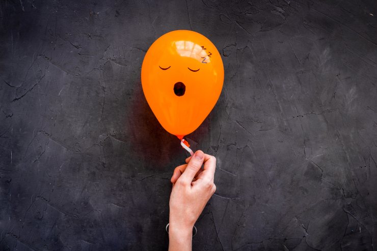 Illustrazione palloncino arancione con smile di stanchezza