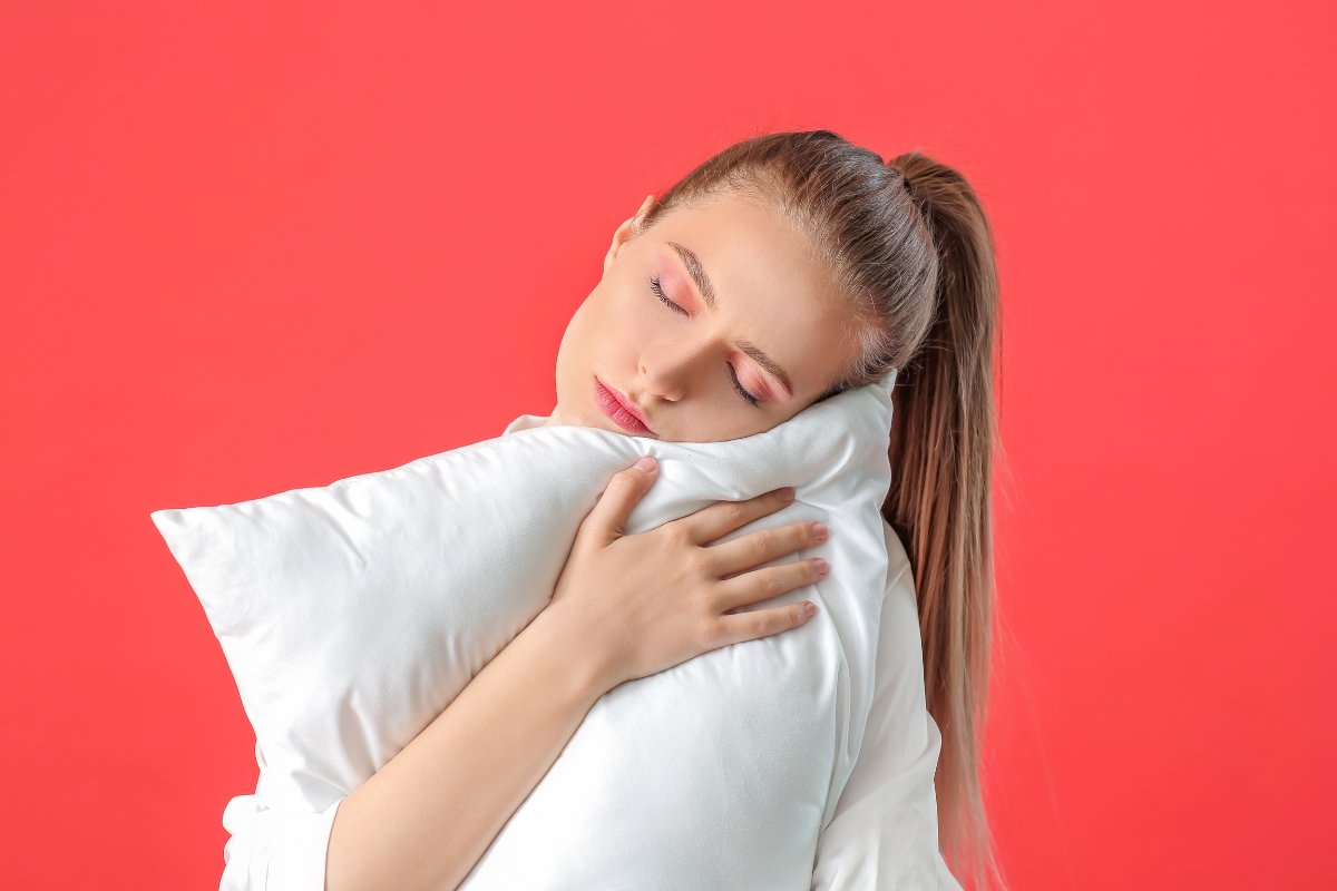 Ragazza stanca che abbraccia un cuscino