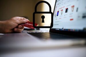 persona davanti ad un computer con in mano una carta di credito