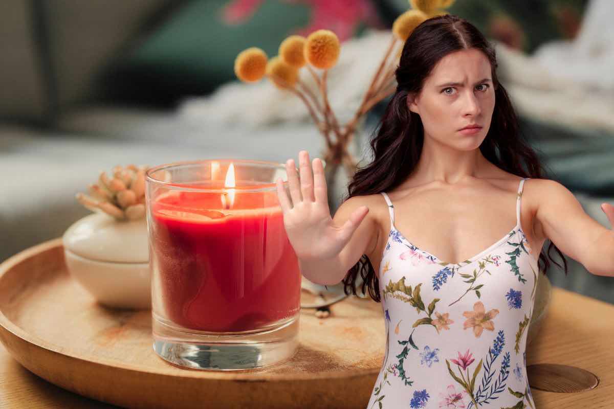 Candela accesa in secondo piano e donna in primo piano