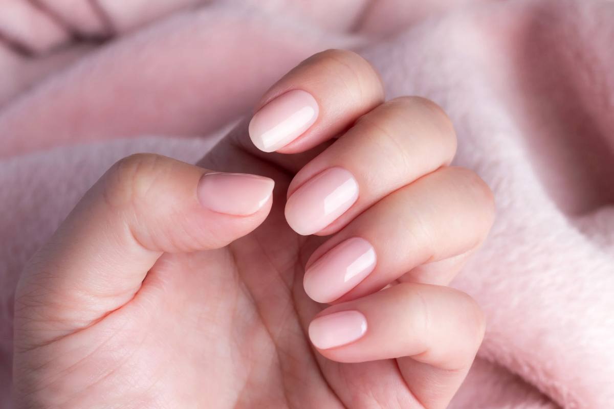 Mano di bambina con gel alle unghie rosa