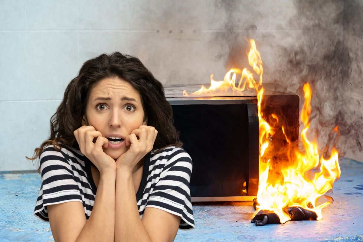 donna spaventata e microonde che ha preso fuoco