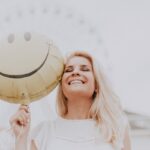 Ragazza sorridente con palloncino di faccina sorridente