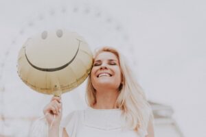 Ragazza sorridente con palloncino di faccina sorridente