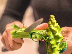 sfondo persona che taglia gambo broccolo e gambo broccolo