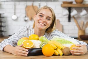 donna seduta con diversi frutti davanti a sé
