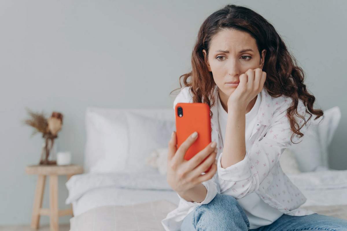 Donna che guarda il cellulare con ansia