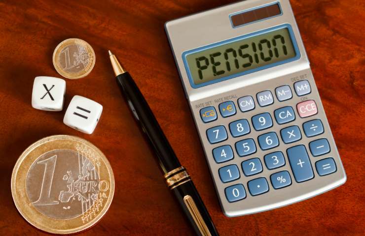 monete in euro, penna e una calcolatrice