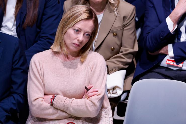 giorgia meloni seduta con le braccia conserte