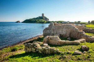 torre di avvistamento e sito archeologico con mare in sardegna