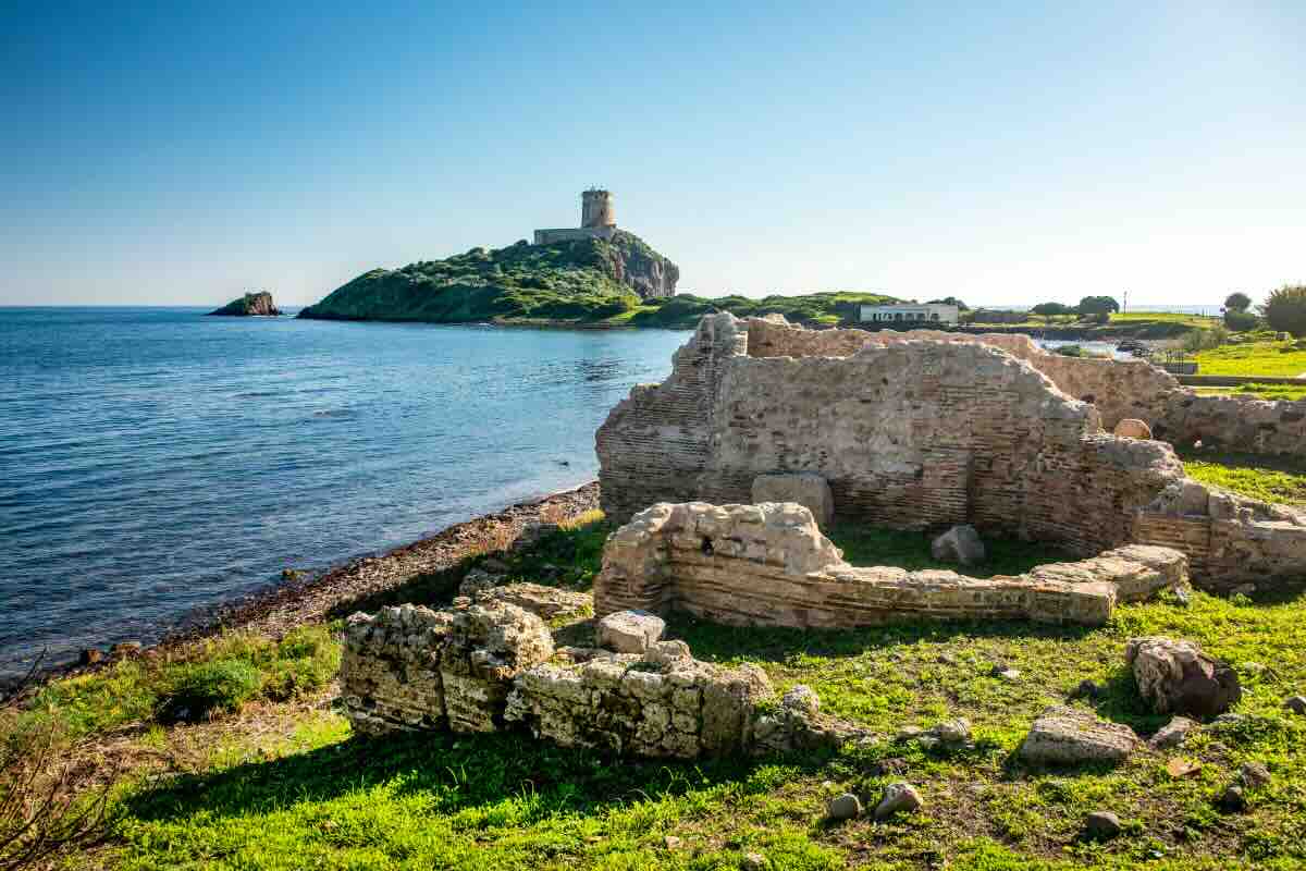 torre di avvistamento e sito archeologico con mare in sardegna