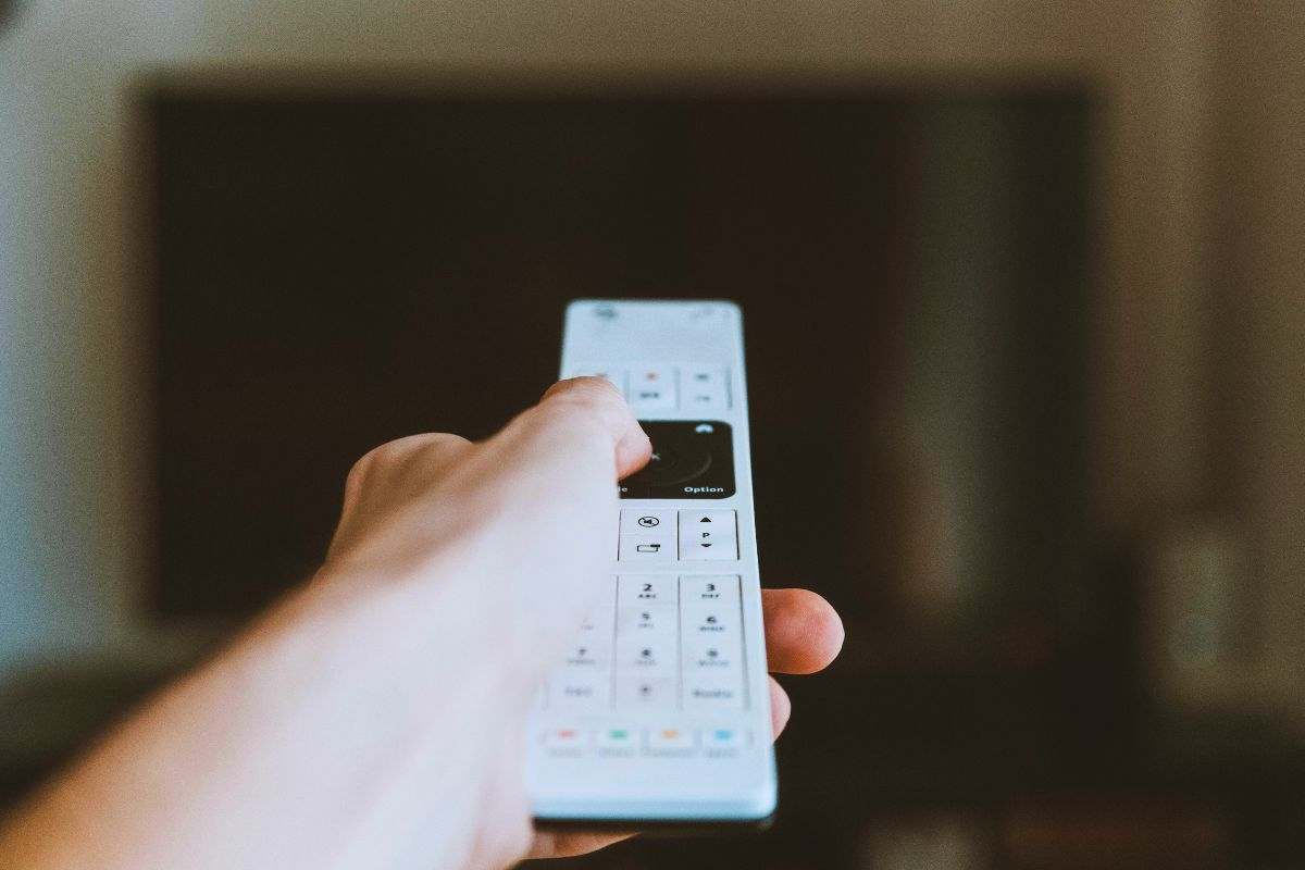 Persona utilizza telecomando per accendere la televisione