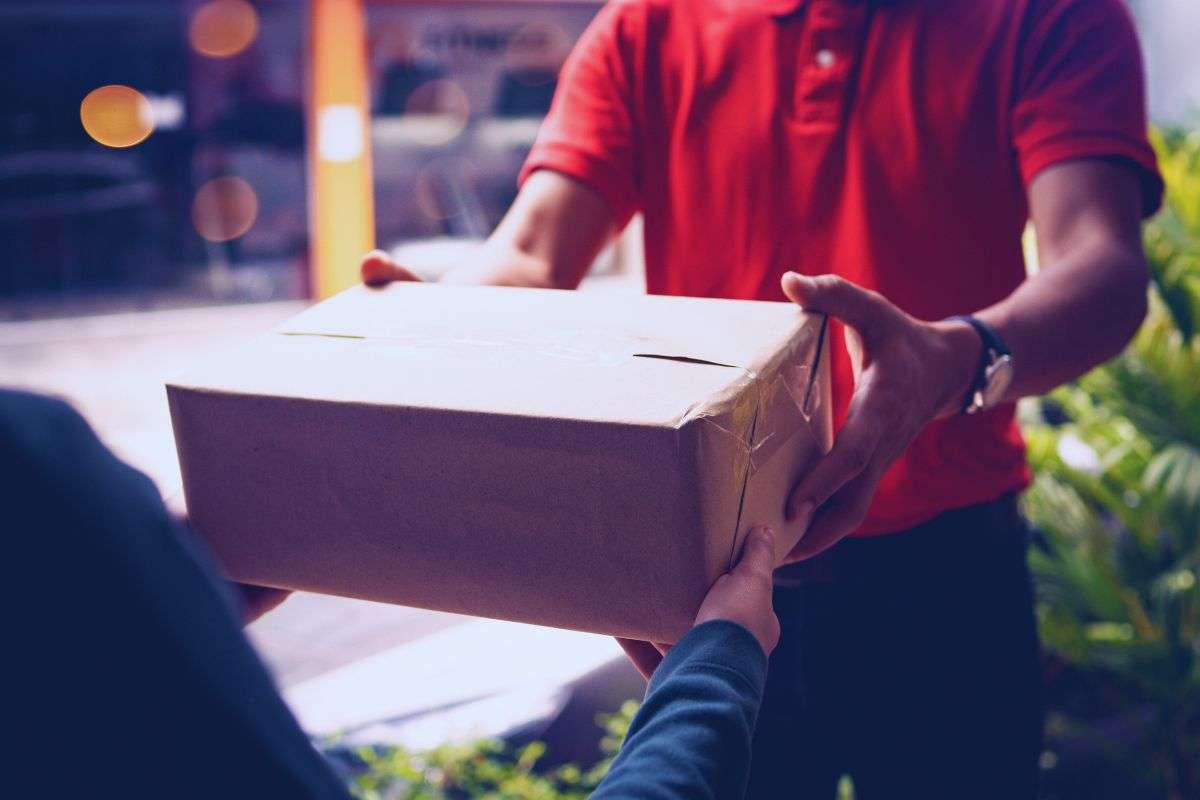 Corriere che consegna pacco a cliente