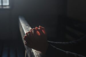 persona che prega in chiesa