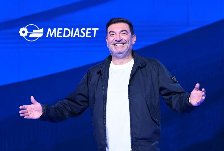 Max Giusti e logo Mediaset