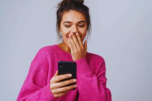 Ragazza con espressione sorpresa mentre guarda smartphone