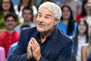 Pino Insegno con le mani congiunte