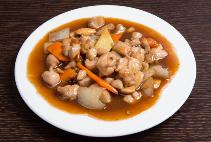 Piatto bianco con del pollo alle mandorle e verdure