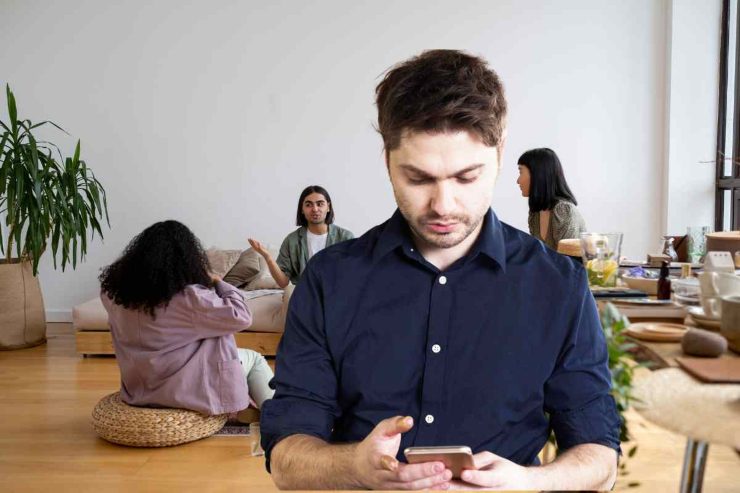 Uomo al cellulare e amici che chiacchierano
