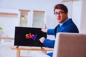 Uomo arrabbiato indica la tv con su il logo Sky