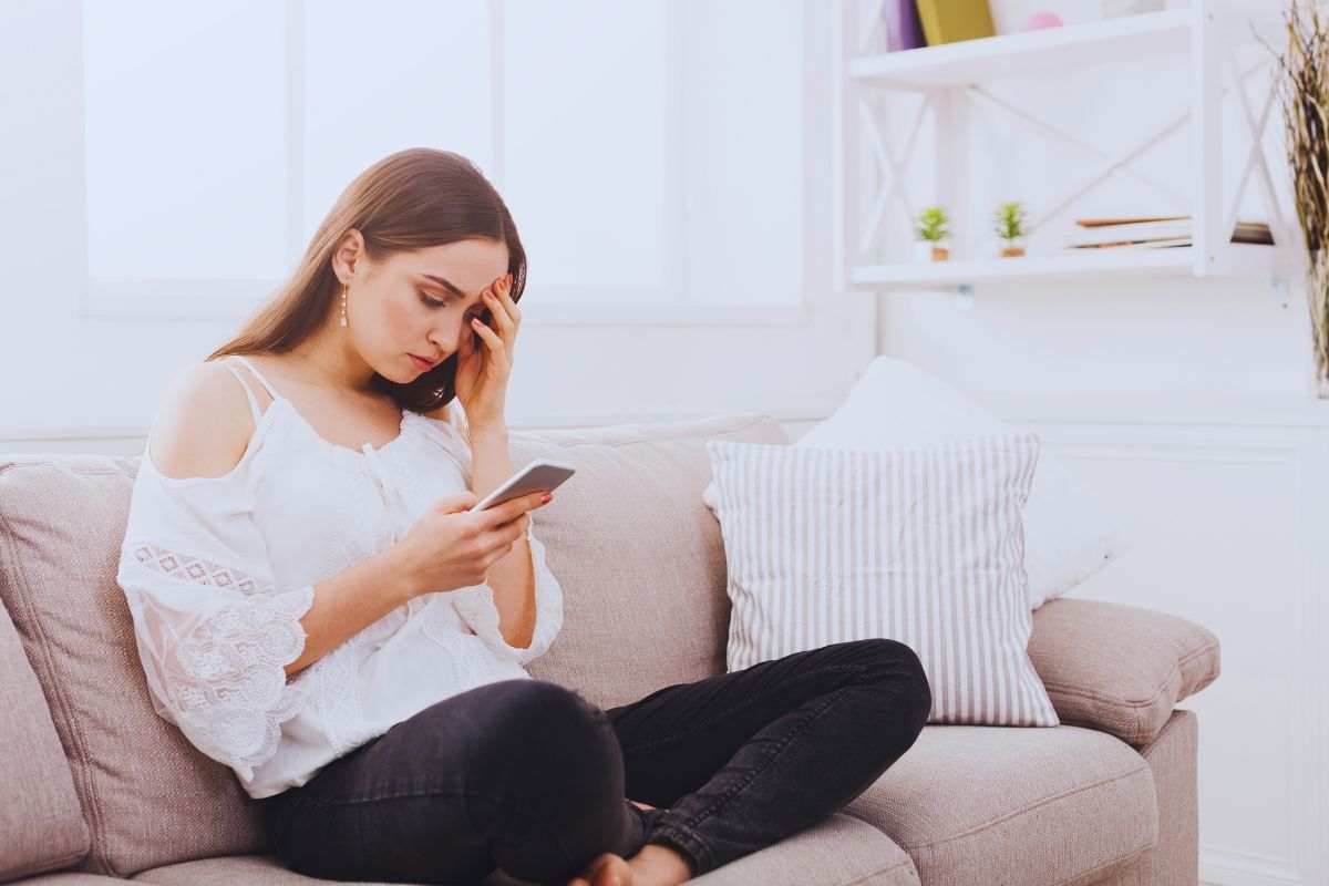 Ragazza preoccupata seduta su divano