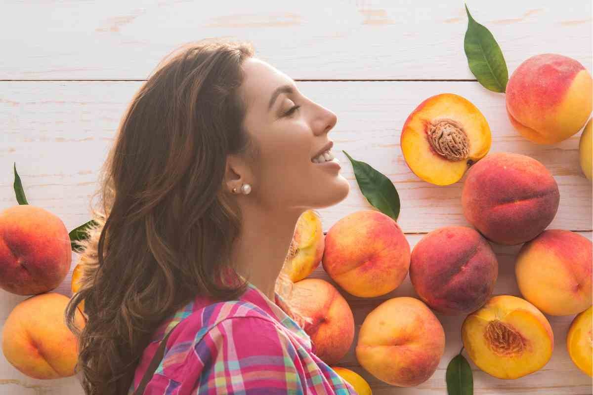 Pesche e donna che sente il profumo