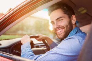 uomo felice in auto