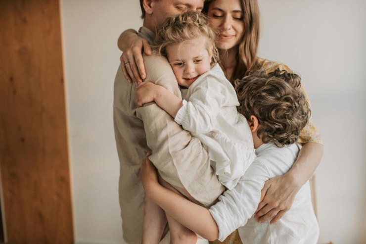 famiglia felice padre madre figlio e figlia in braccio