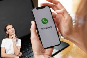 Mano con smartphone e logo whatsapp, ragazza pensierosa
