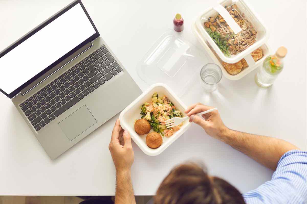 Person che mangia davanti al computer