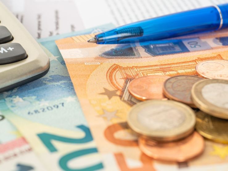 banconote e monete euro con calcolatrice e penna