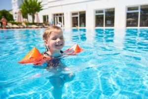 Bambina in piscina con i braccioli
