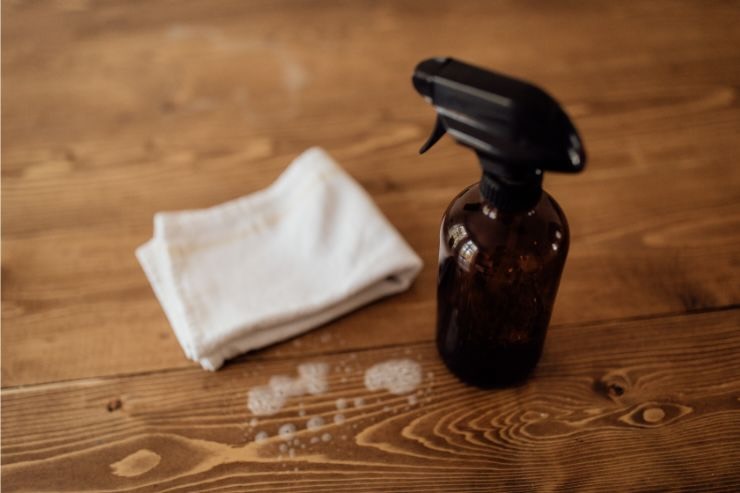 Erogatore spray e panno su superficie di legno