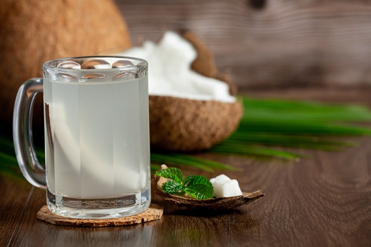 Bicchiere di vetro pieno di acqua di cocco