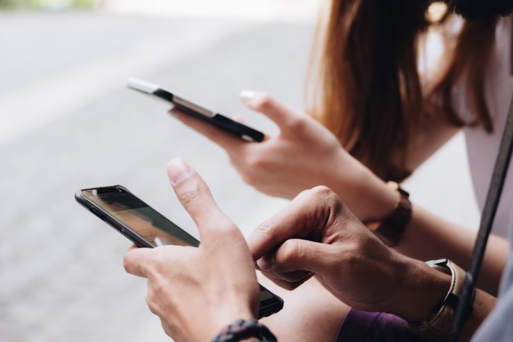 uomini e donne con cellulare in mano