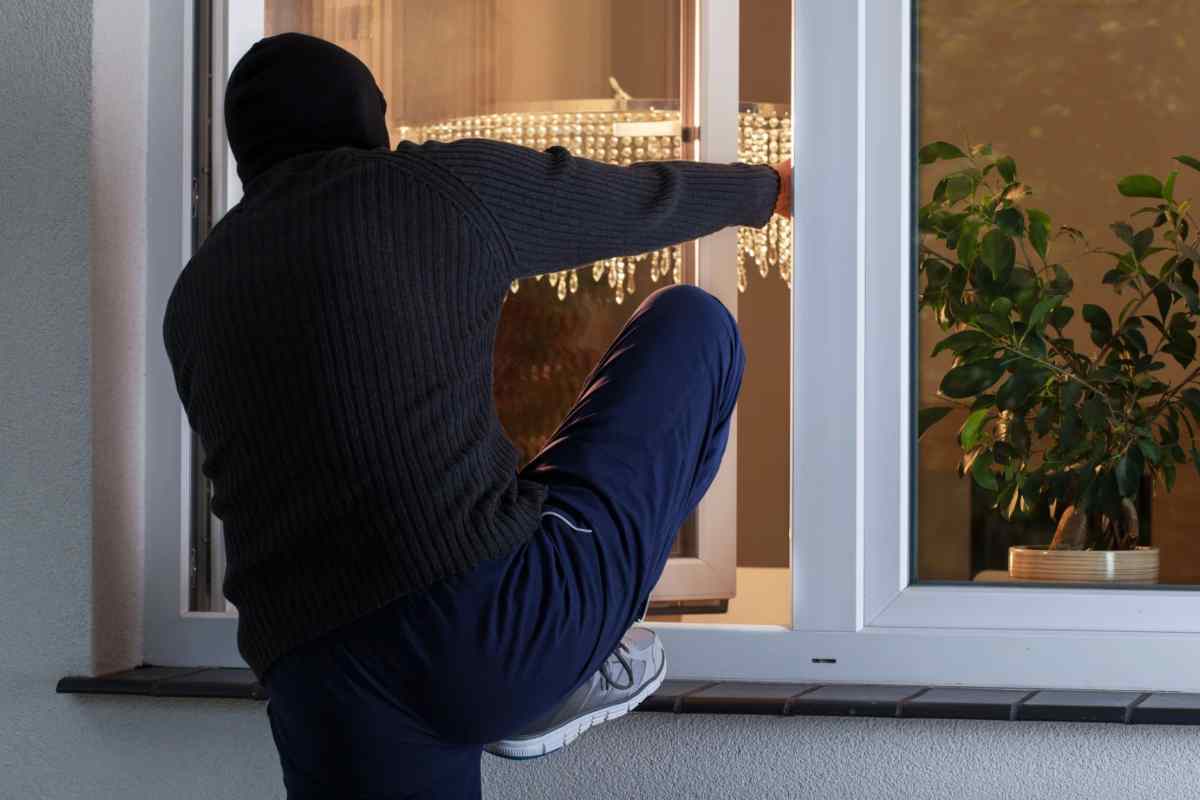 Uomo che cerca di entrare in casa dalla finestra