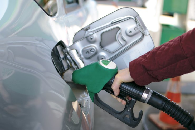 Uomo che fa rifornimento per la sua auto: pompa di benzina dentro serbatoio