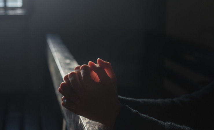 persona che prega in chiesa