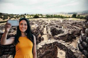 Su Nuraxi di Barumini e ragazza fa selfie